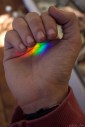 Photograph of hand holding a rainbow