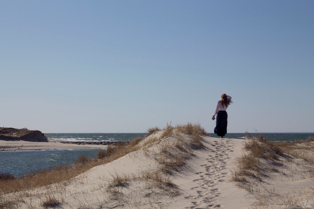 Woman Looking out to ocean on dune